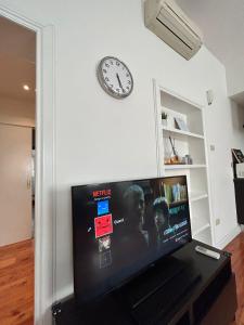 a clock on a wall above a flat screen tv at Domus Montebello in Rome