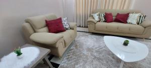 sala de estar con 2 sillas y sofá en Sami BnB - Apt 05 Makongo after Mlimani City, en Dar es Salaam