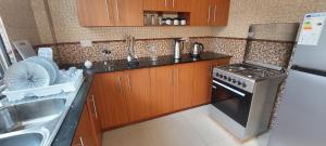 y cocina con fogones, fregadero y nevera. en Sami BnB - Apt 05 Makongo after Mlimani City, en Dar es Salaam