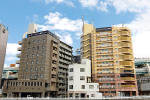 eine Gruppe großer Gebäude in einer Stadt in der Unterkunft HOTEL Third Place Hakata in Fukuoka