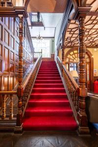 a red carpeted staircase in a building at Palmers Lodge Swiss Cottage in London