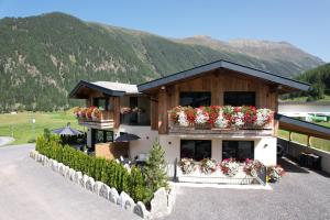 un edificio con fioriere e montagne sullo sfondo di Alp Apart Niederthai a Umhausen