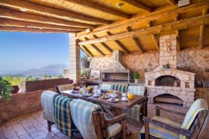 eine Terrasse mit einem Tisch und einem Steinkamin in der Unterkunft Samonas Traditional Villas in Samonás