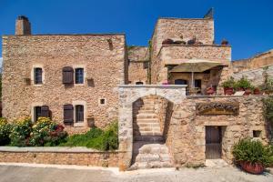 ein altes Steingebäude mit einem Torbogen davor in der Unterkunft Samonas Traditional Villas in Samonás