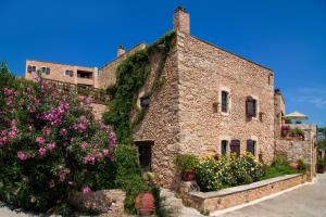 ein Steingebäude mit Blumen davor in der Unterkunft Samonas Traditional Villas in Samonás