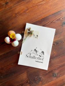 una carta con uova e fiori su un tavolo di legno di Schallerhof Sterzing - Deine Auszeit mit Ausblick in unseren Ferienwohnungen auf dem Bergbauernhof in Südtirol a Vipiteno