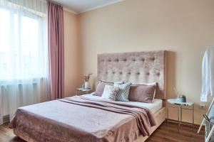 sypialnia z dużym łóżkiem i dużym oknem w obiekcie Central Two room Lux Apartments w mieście Mukaczewo