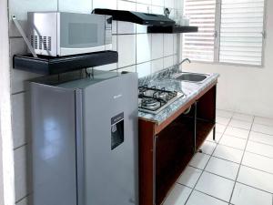 a kitchen with a refrigerator and a microwave at Departamentos 1E in Puerto Vallarta