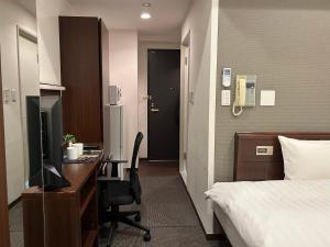 een hotelkamer met een bed en een bureau met een computer bij Cypressinn Tokyo in Tokyo