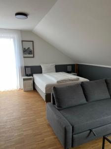 a bedroom with a bed and a couch at New Age Boardinghaus Bad Wimpfen in Bad Wimpfen