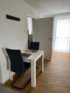 a white table and two chairs in a room at New Age Boardinghaus Bad Wimpfen in Bad Wimpfen