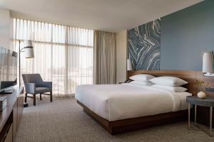 een slaapkamer met een groot wit bed en een stoel bij Hyatt Regency Houston Galleria in Houston