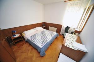 - une petite chambre avec un lit et une table dans l'établissement Rooms Novaković, à Opatija