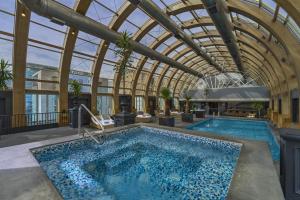 uma piscina interior com tecto de vidro e uma piscina em The Ritz-Carlton, Santiago em Santiago