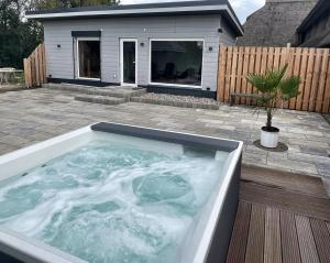 una bañera de hidromasaje en un patio frente a una casa en Mare Balticum Urlaub auf Rügen, en Sagard