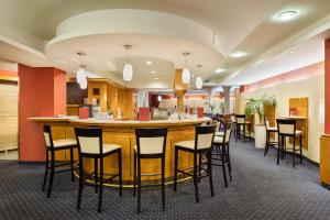 a bar in a restaurant with chairs around it at Austria Trend Hotel Ananas Wien in Vienna