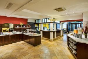 a large kitchen with red walls and a large island at Austria Trend Hotel Ananas Wien in Vienna