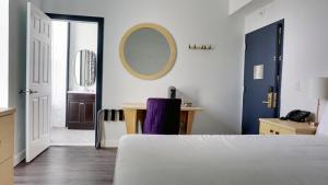 una camera con letto, scrivania e specchio di Hotel Callista a Norwich