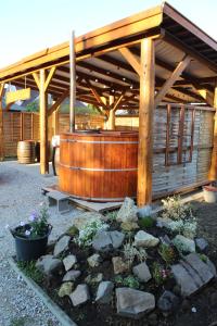 - un bâtiment en bois avec un bain à remous dans le jardin dans l'établissement Borács Winedégház, à Bogács