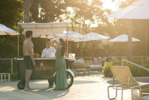 a man and a woman standing next to a food cart at Hotel Villa Rossa in São Roque