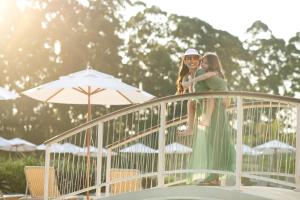 two girls are standing on a railing at Hotel Villa Rossa in São Roque