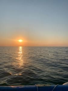 een zonsondergang over de oceaan met een boot in het water bij B Ensuite Appartment con Zona de Patio in Arrecife