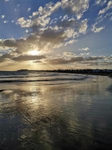 een uitzicht op een strand met zonsondergang bij B Ensuite Appartment con Zona de Patio in Arrecife