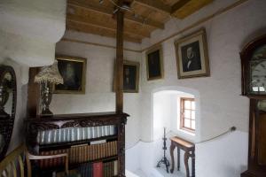 um quarto com uma estante de livros e um relógio em The Manor at Plane Castle em Falkirk