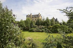 um velho castelo no meio de um jardim em The Manor at Plane Castle em Falkirk