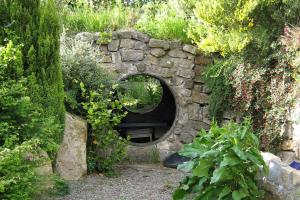 uma parede de pedra com um banco num jardim em The Manor at Plane Castle em Falkirk