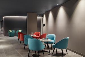 a dining room with tables and chairs and lights at Punthill Caroline Springs in Caroline Springs