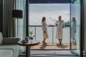 eine Gruppe von Personen, die auf einem Balkon in einem Hotelzimmer stehen in der Unterkunft Hotel Mikołajki Leisure & SPA - Destigo Hotels in Mikołajki