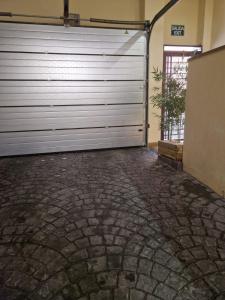 a garage door in a building with a brick driveway at La Casona del Eboni in Alcalá de Henares