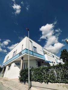 un bâtiment blanc avec une bande bleue dans l'établissement Hotel Airone, à Alberobello