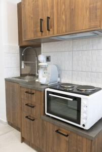 una cucina con forno a microonde e lavandino di Aigli Guest House a Gythio