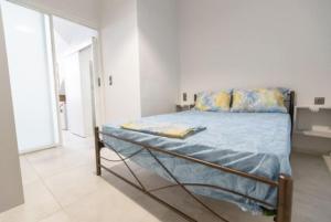 una camera da letto con un letto con lenzuola blu e uno specchio di Aigli Guest House a Gythio