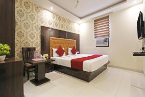 a hotel room with a bed and a desk at Iconic Inn Near Delhi IGI Airport in New Delhi