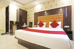 a bedroom with a large white bed with red pillows at Iconic Inn Near Delhi IGI Airport in New Delhi