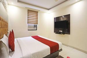 a bedroom with a bed and a flat screen tv at Iconic Inn Near Delhi IGI Airport in New Delhi