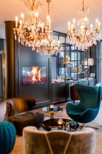 a living room with a fireplace and a chandelier at Motel One Berlin-Bellevue in Berlin