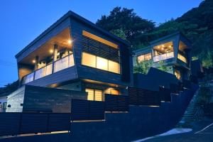 une maison avec un escalier menant à elle la nuit dans l'établissement ルクス箱根湯本 LUX HAKONE YUMOTO, à Hakone