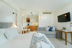 sala de estar con cama y sofá en ILIORAMA LUXURY SUITES, en Skala Potamias