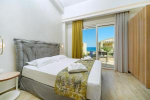 1 dormitorio con cama y vistas al océano en ILIORAMA LUXURY SUITES, en Skala Potamias