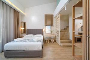 1 dormitorio con 1 cama y escalera en ILIORAMA LUXURY SUITES, en Skala Potamias