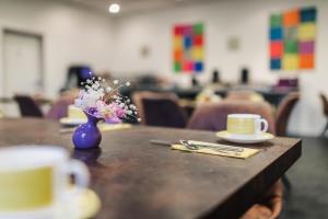 uma mesa com um vaso azul com flores em Hotel Seeblick em Barhöft