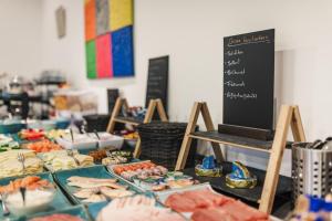 uma mesa com diferentes tipos de alimentos e um quadro-negro em Hotel Seeblick em Barhöft