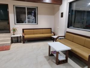 salon z 2 kanapami i stołem w obiekcie Hotel Darshan Grand w mieście Kolhapur