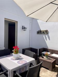 a white table with chairs and a white umbrella at Casa Giuliani in Porto Cesareo