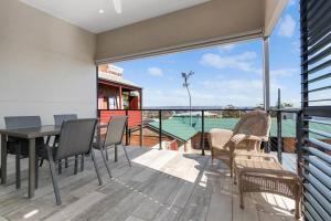 balcone con tavolo, sedie e vista sull'oceano di Classic Elegance on The Hill a Newcastle