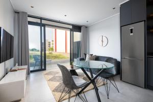 a kitchen with a glass table and some chairs at Luxury Bellagio 003 One Bed with Inverter in Durban